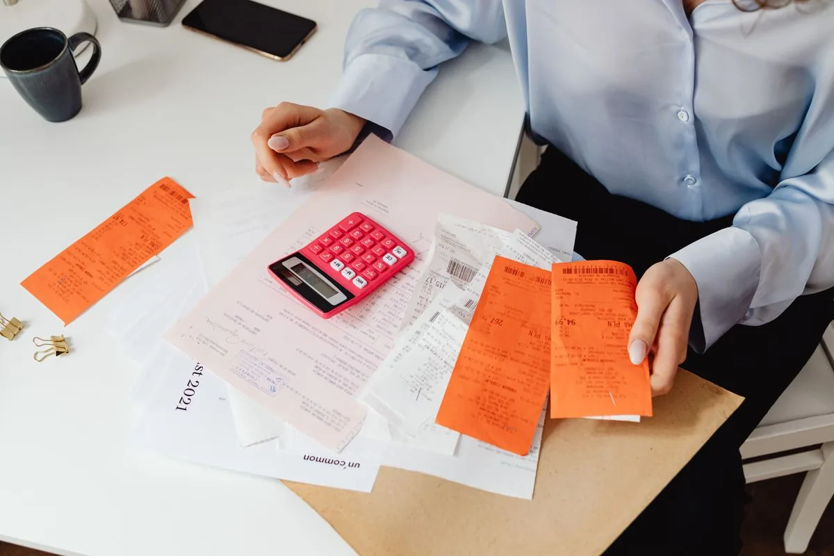 Quittungen, Taschenrechner und Notizblock auf einem Tisch
